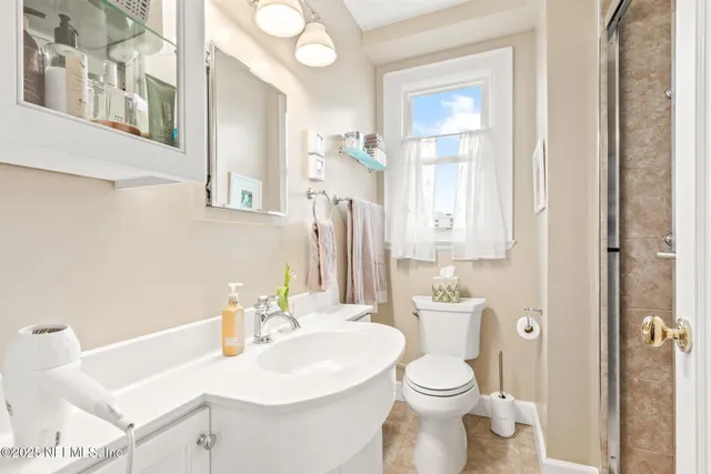 a bathroom with a sink a toilet and a mirror