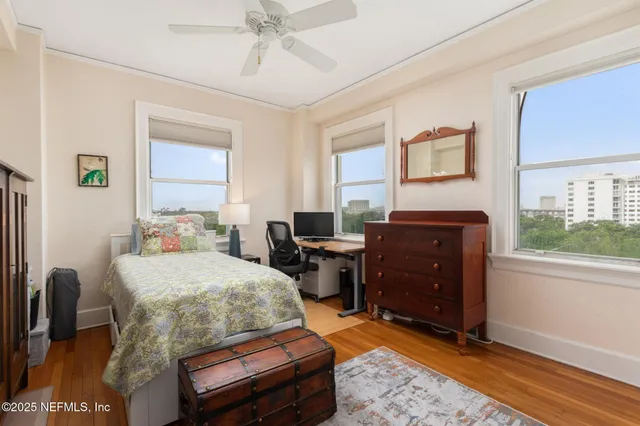 a bedroom with a bed and wooden floor