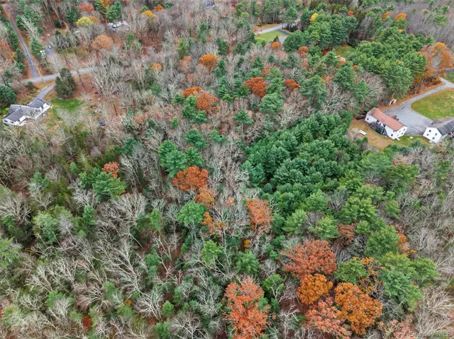 an aerial view of a houses with a lush green hillside