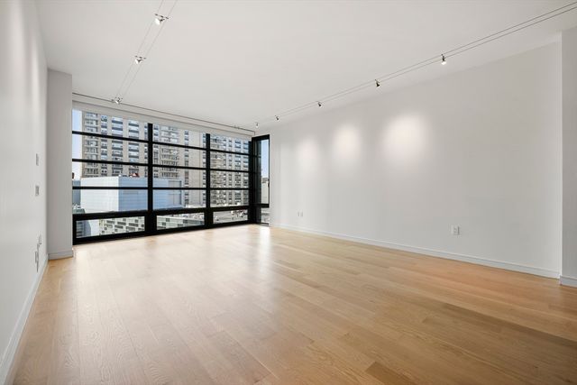 a view of a room with wooden floor and window