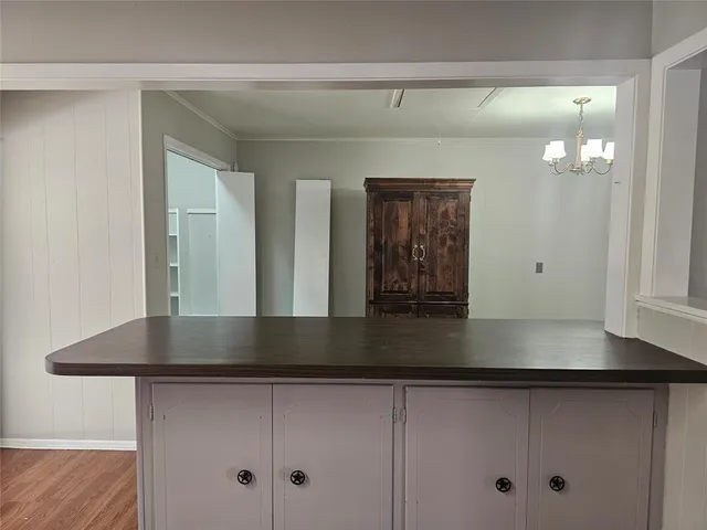 a view of a hallway with entryway and chandelier