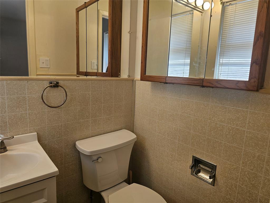 604 East 4th Street Weatherford, TX 76086 - Photo 10 of 20 a bathroom with a toilet sink and mirror