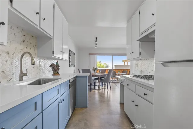 a kitchen with white cabinets and appliances