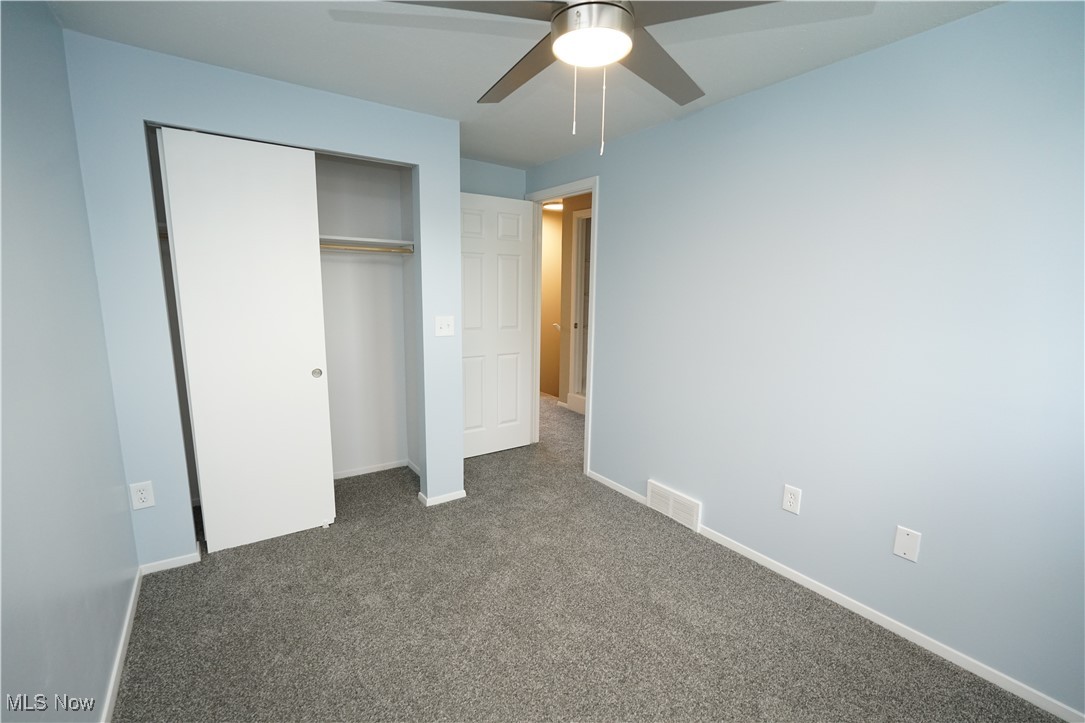 8749 West Ridge Road Elyria, OH 44035 - Photo 12 of 16 Unfurnished bedroom featuring carpet floors, a closet, and a ceiling fan