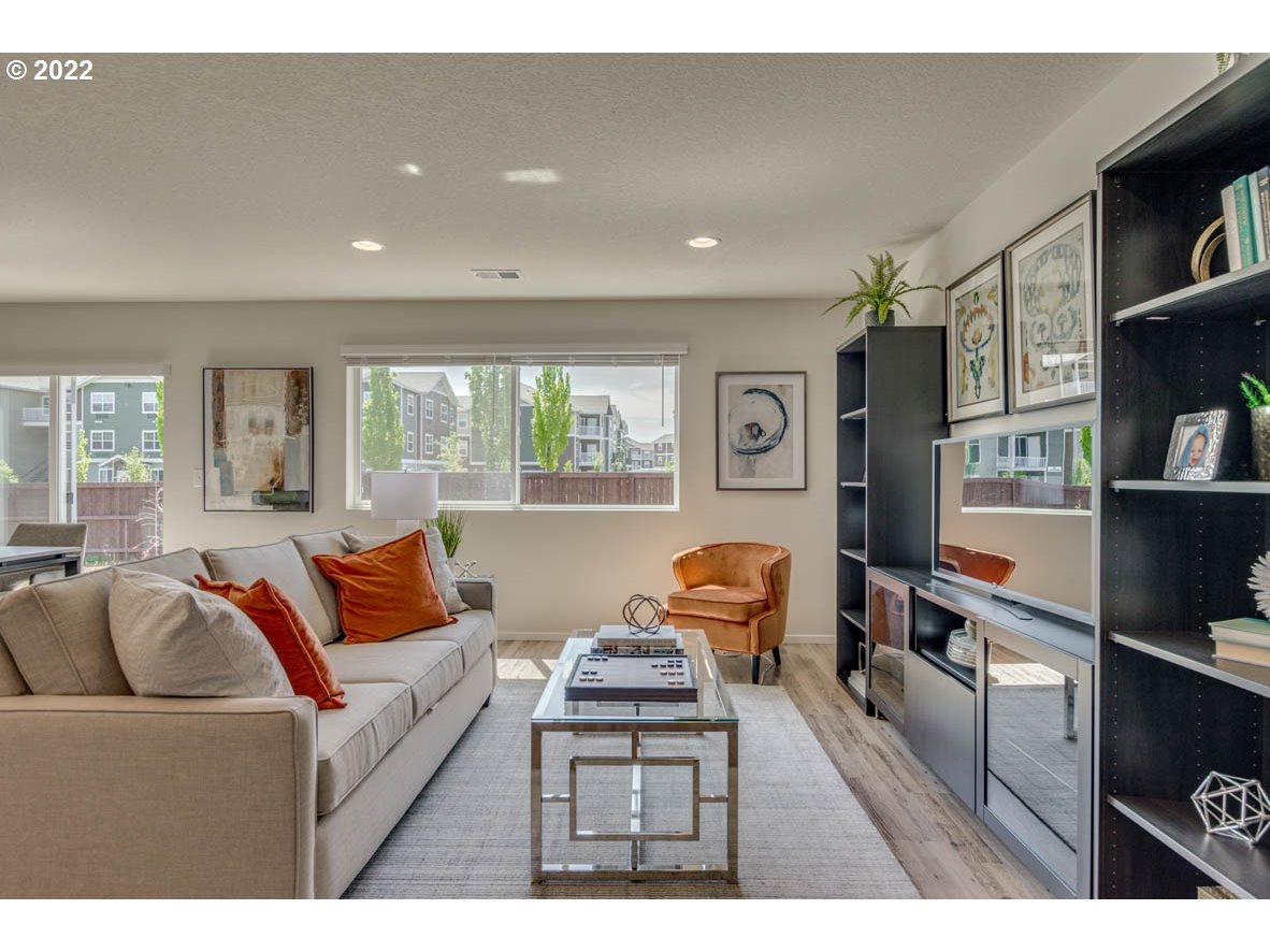 2866 Pierce Parkway Springfield, OR 97477 - Photo 3 of 14 a living room with furniture a flat screen tv and a book shelf