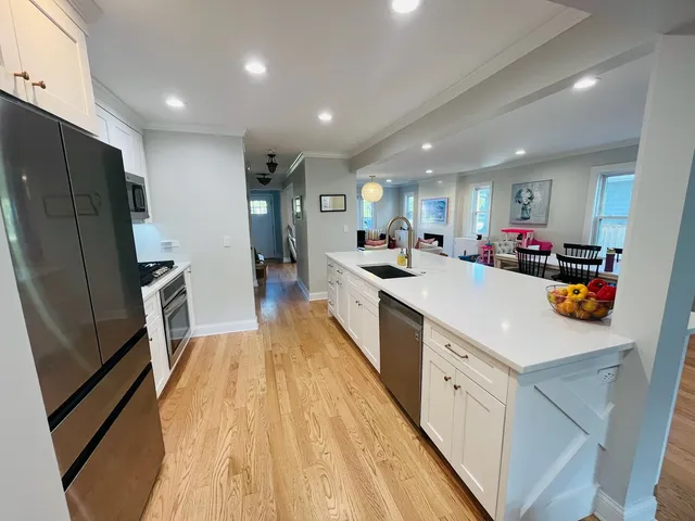 a kitchen that has a lot of cabinets a sink and wooden floor