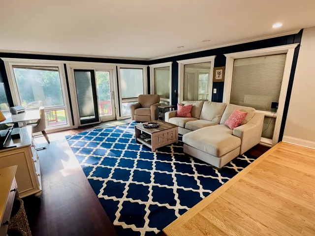 a living room with furniture and a floor to ceiling window