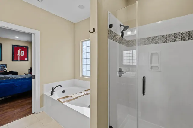 a bathroom with a tub sink and mirror