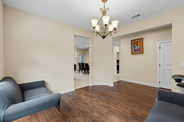 a living room with furniture and a chandelier