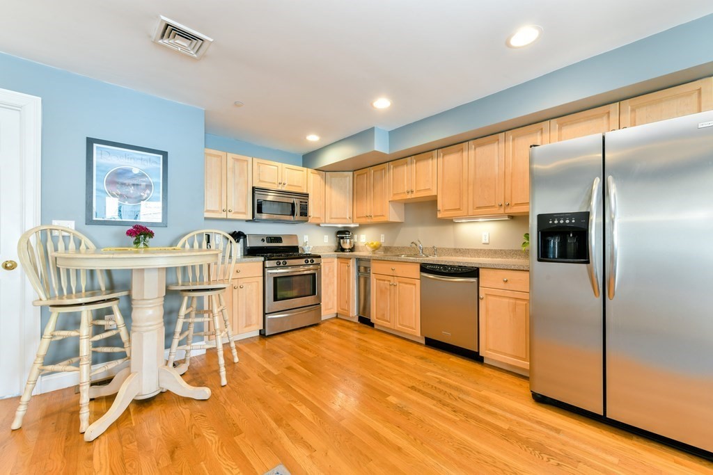 2 Lee Hill Road, Unit 6 Boston, MA 02131 - Photo 13 of 42 a kitchen with granite countertop a refrigerator cabinets and wooden floor