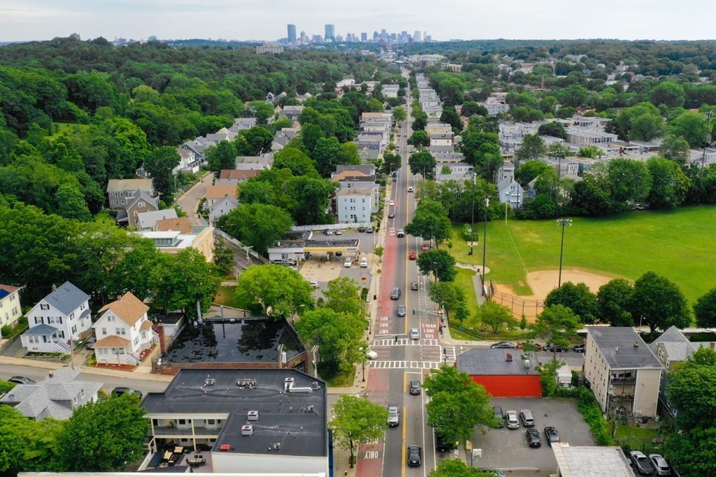 2 Lee Hill Road, Unit 6 Boston, MA 02131 - Photo 8 of 42 an aerial view of a city with lots of residential buildings and mountain view in back