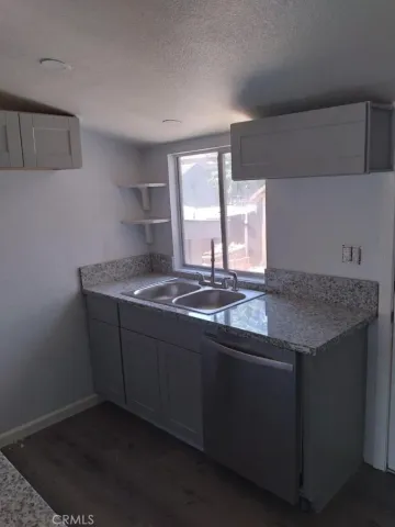 a kitchen with granite countertop a sink and a stove
