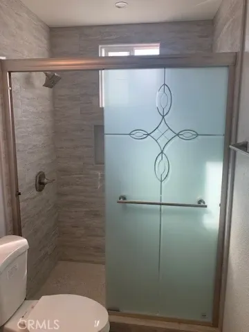 a bathroom with a toilet and a shower