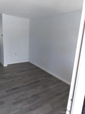 a view of a small space with wooden floor and a window