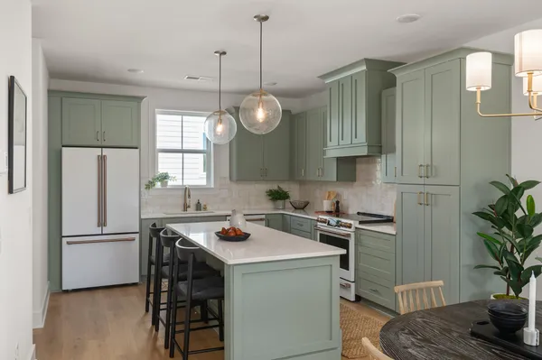 a kitchen with a refrigerator a stove a sink and cabinets