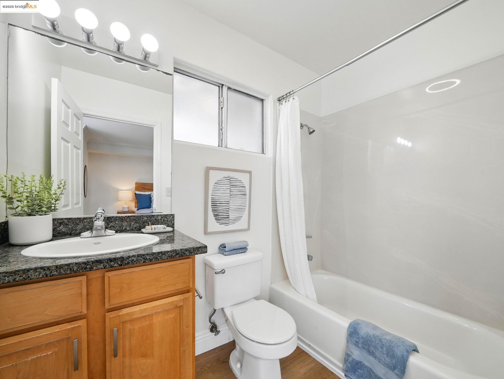 1515 14th Avenue, Unit 201 Oakland, CA 94606 - Photo 11 of 23 a bathroom with a granite countertop sink toilet and shower