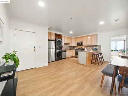 a kitchen with stainless steel appliances kitchen island granite countertop a refrigerator and a dining table