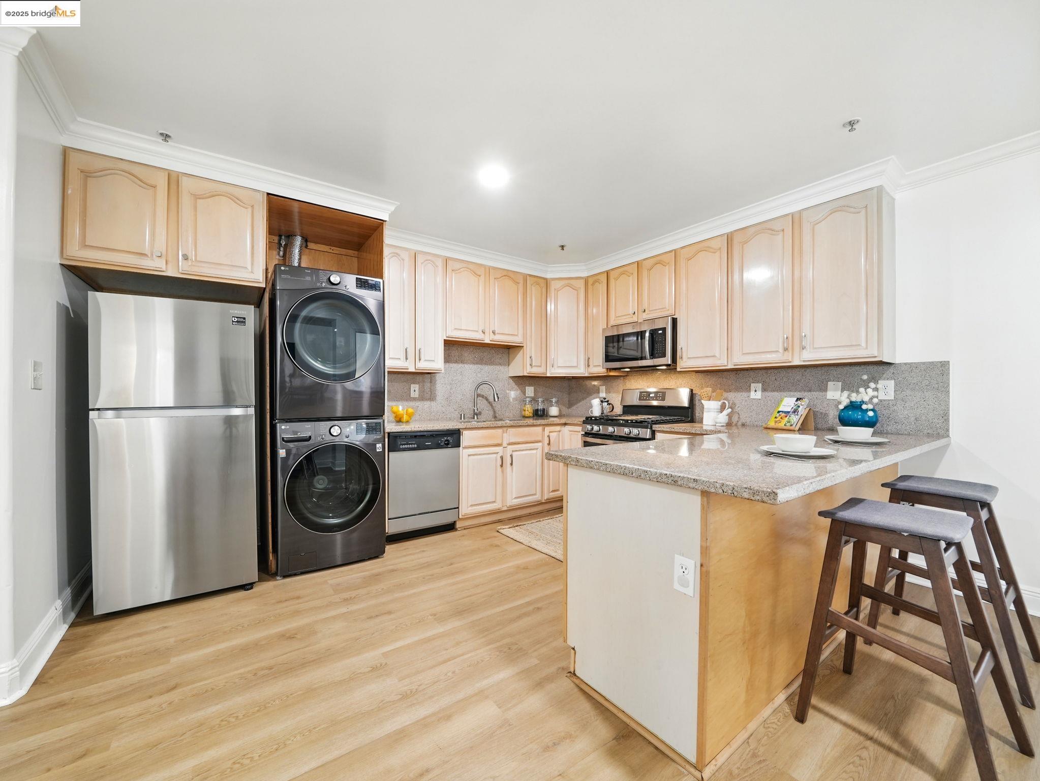 1515 14th Avenue, Unit 201 Oakland, CA 94606 - Photo 6 of 23 a kitchen with refrigerator a stove a washer and dryer