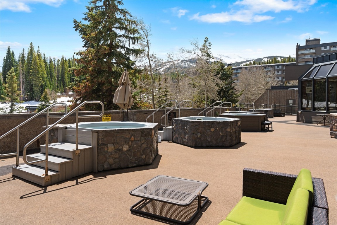 640 Village Road, Unit 4220 Breckenridge, CO 80424 - Photo 21 of 34 View of patio / terrace featuring a hot tub, an outdoor fire pit, and a mountain view