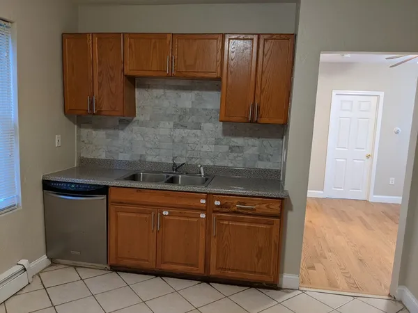 a kitchen with granite countertop a sink a stove and cabinets