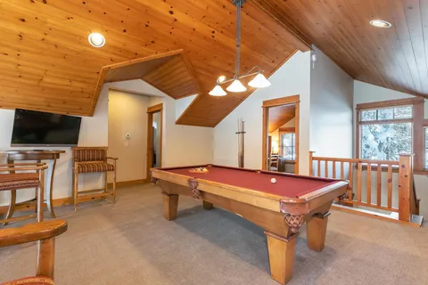 a pool table chairs and flat screen tv