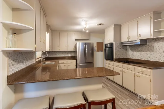 a kitchen with kitchen island a counter top space a sink stainless steel appliances and cabinets