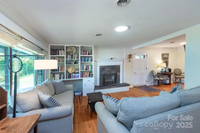 a living room with furniture a fireplace and a large window