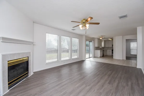 a view of an empty room with a fireplace and window
