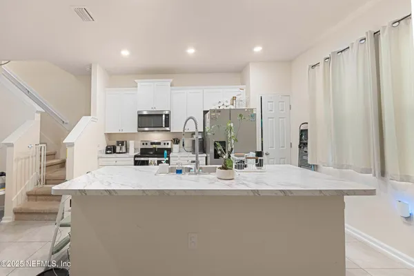a kitchen with a sink and steel appliances