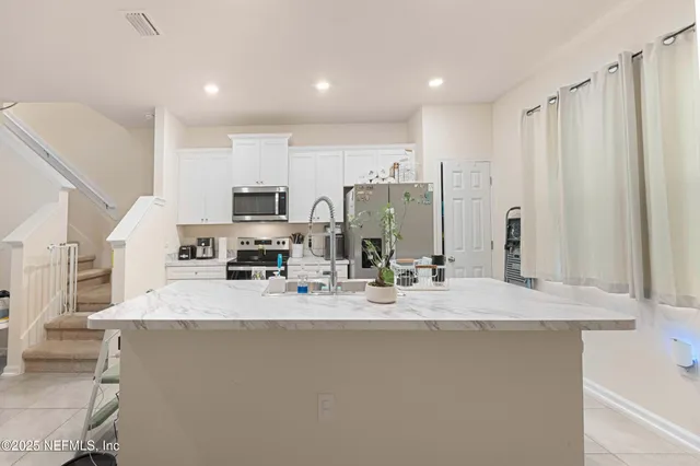 a kitchen with a sink and steel appliances
