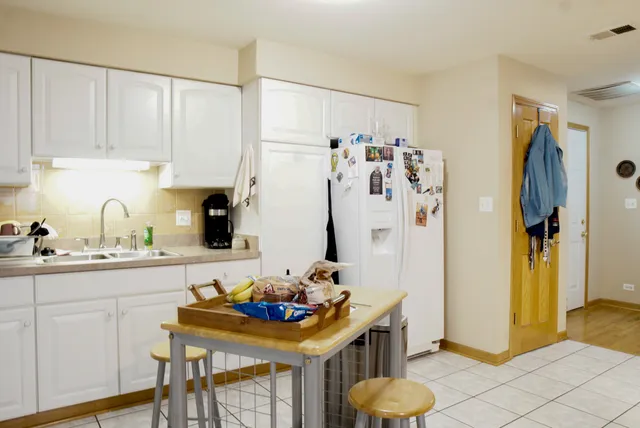 a kitchen with stainless steel appliances kitchen island granite countertop a refrigerator and a sink