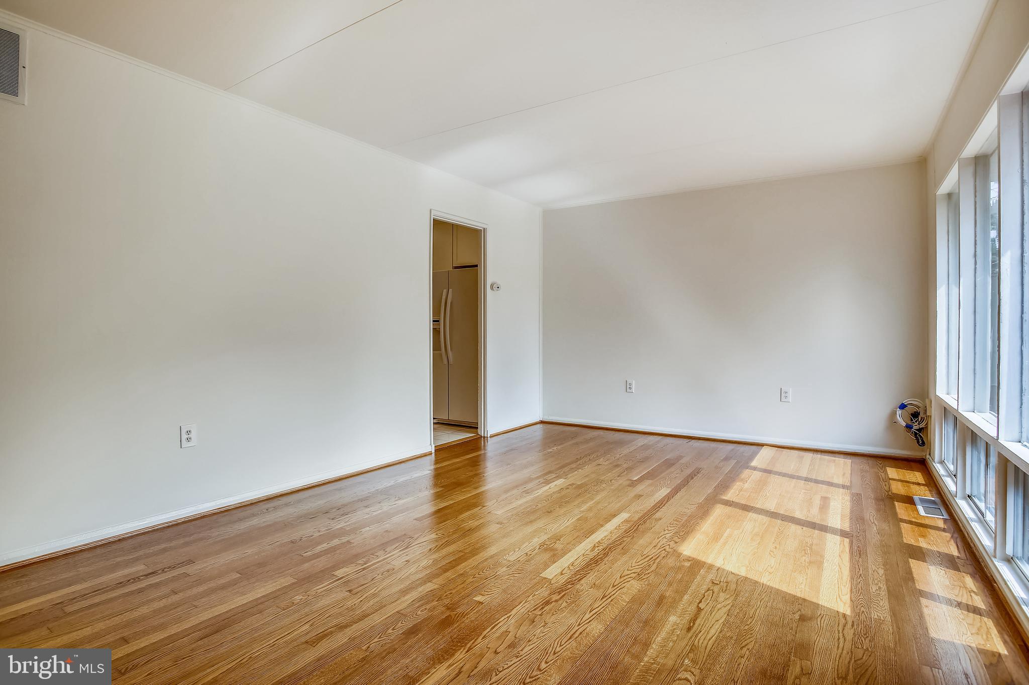 10216 Rodgers Road Fairfax, VA 22030 - Photo 13 of 20 a view of an empty room with wooden floor and a window