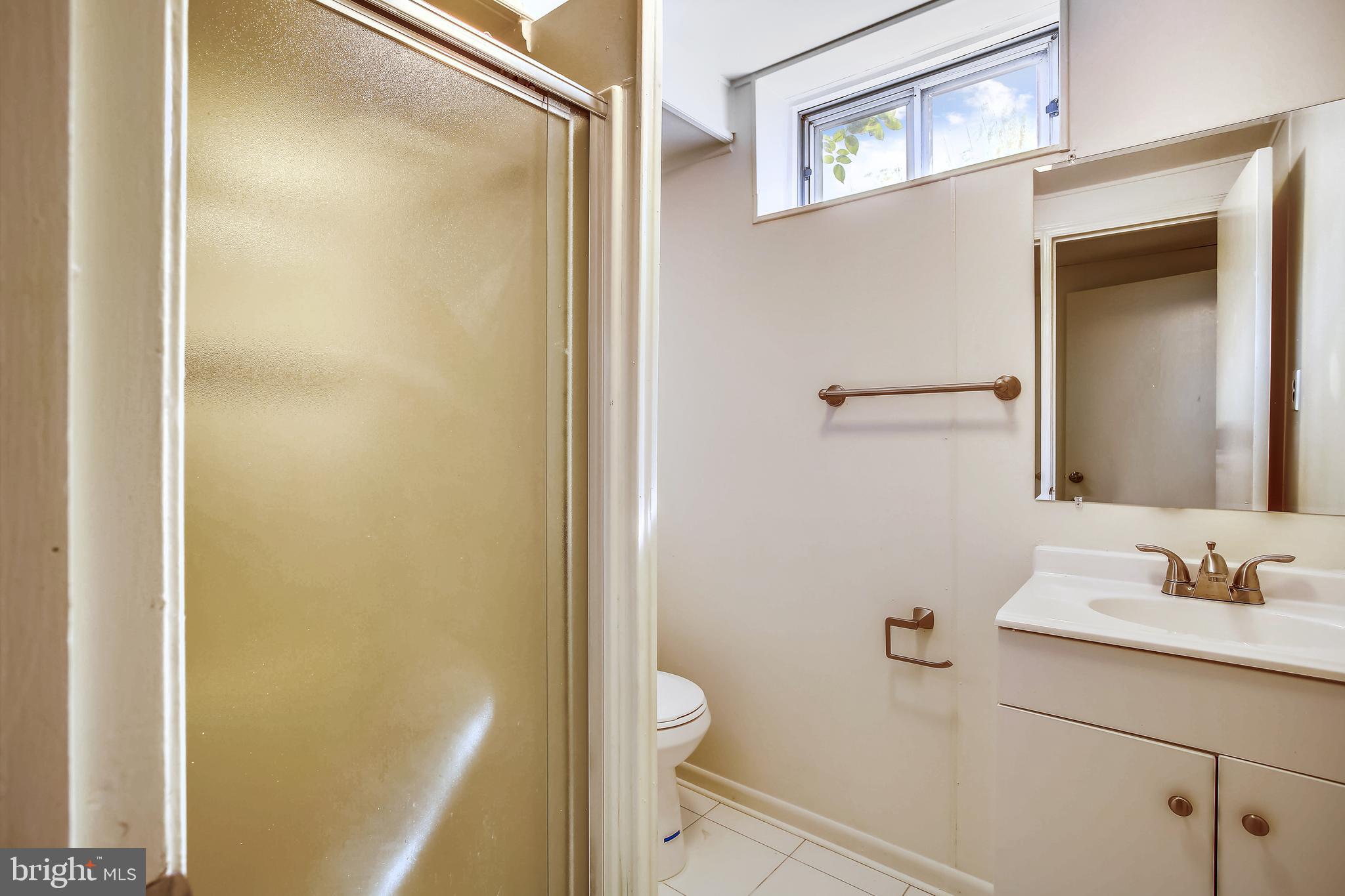 10216 Rodgers Road Fairfax, VA 22030 - Photo 15 of 20 a bathroom with a granite countertop sink toilet and shower