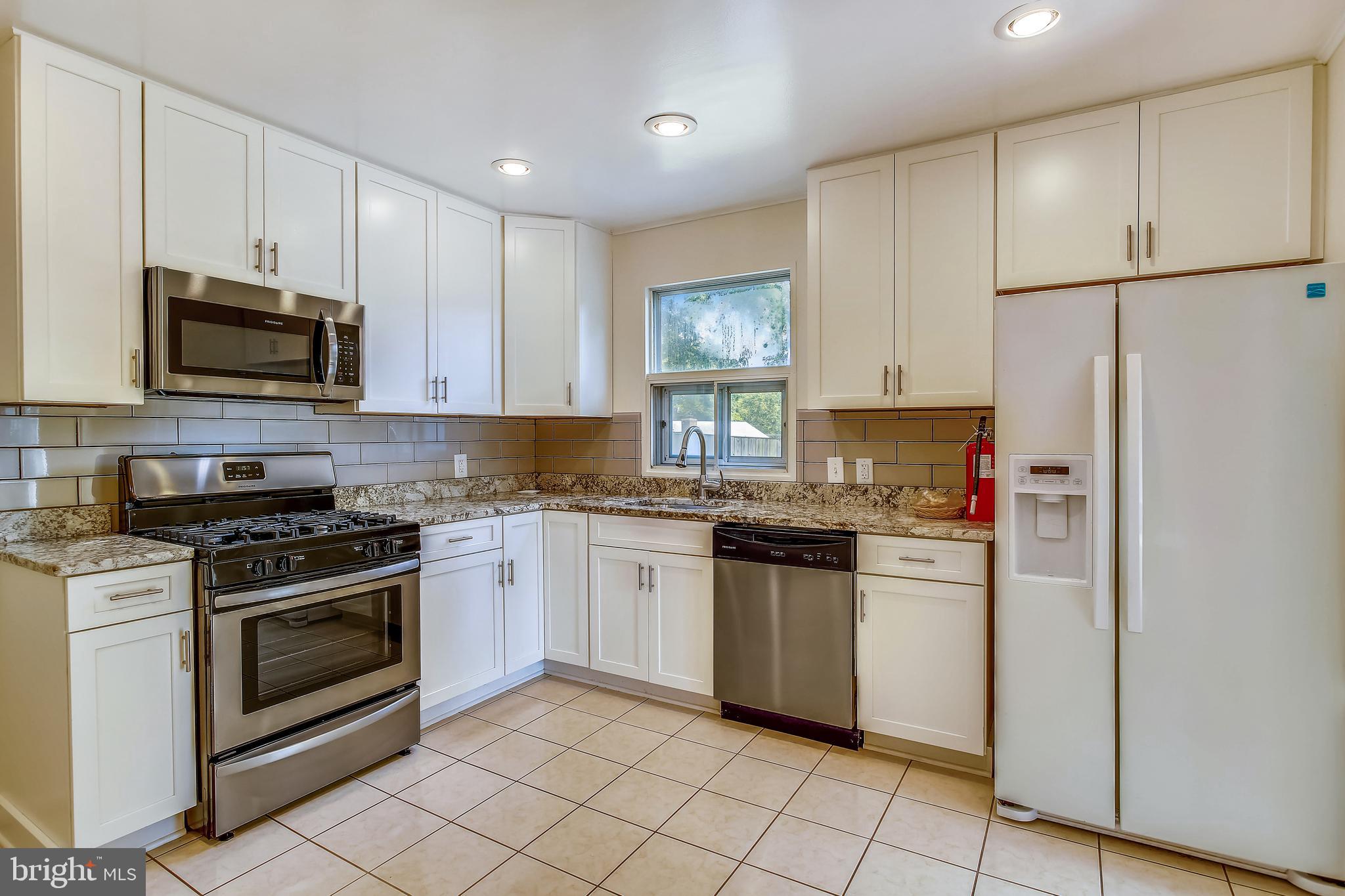 10216 Rodgers Road Fairfax, VA 22030 - Photo 5 of 20 a kitchen with stainless steel appliances granite countertop a stove a refrigerator and a microwave