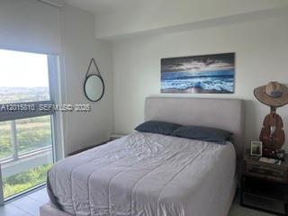2000 Metropica Way, Unit 1902 Sunrise, FL 33323 - Photo 2 of 7 a bedroom with a bed and wooden floor