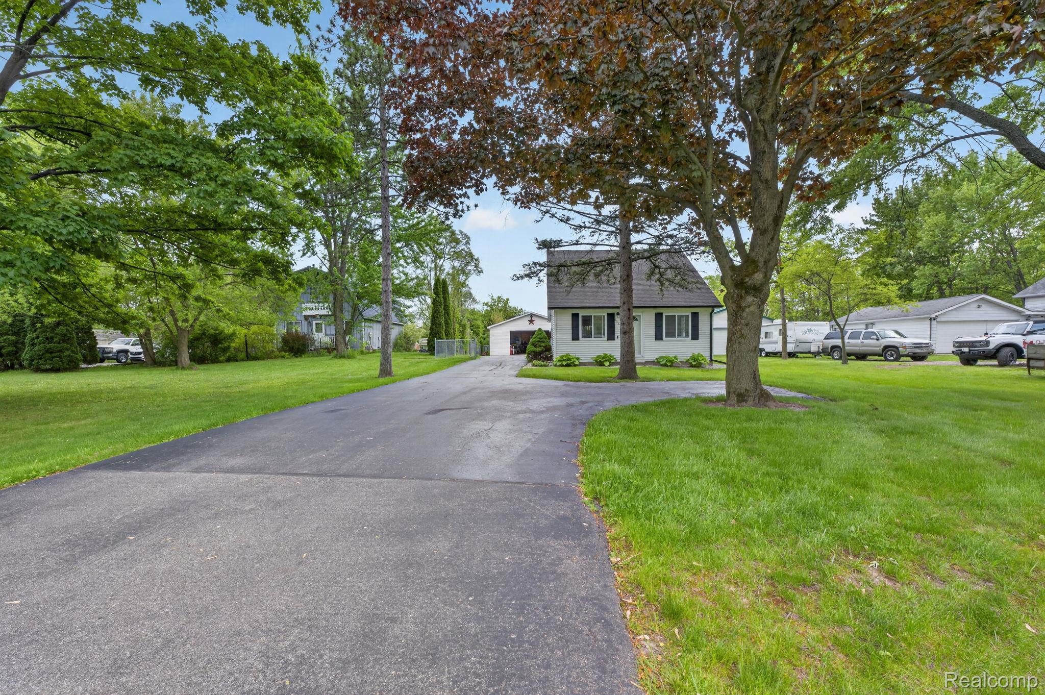 View of front of home with a front yard and a detached garage