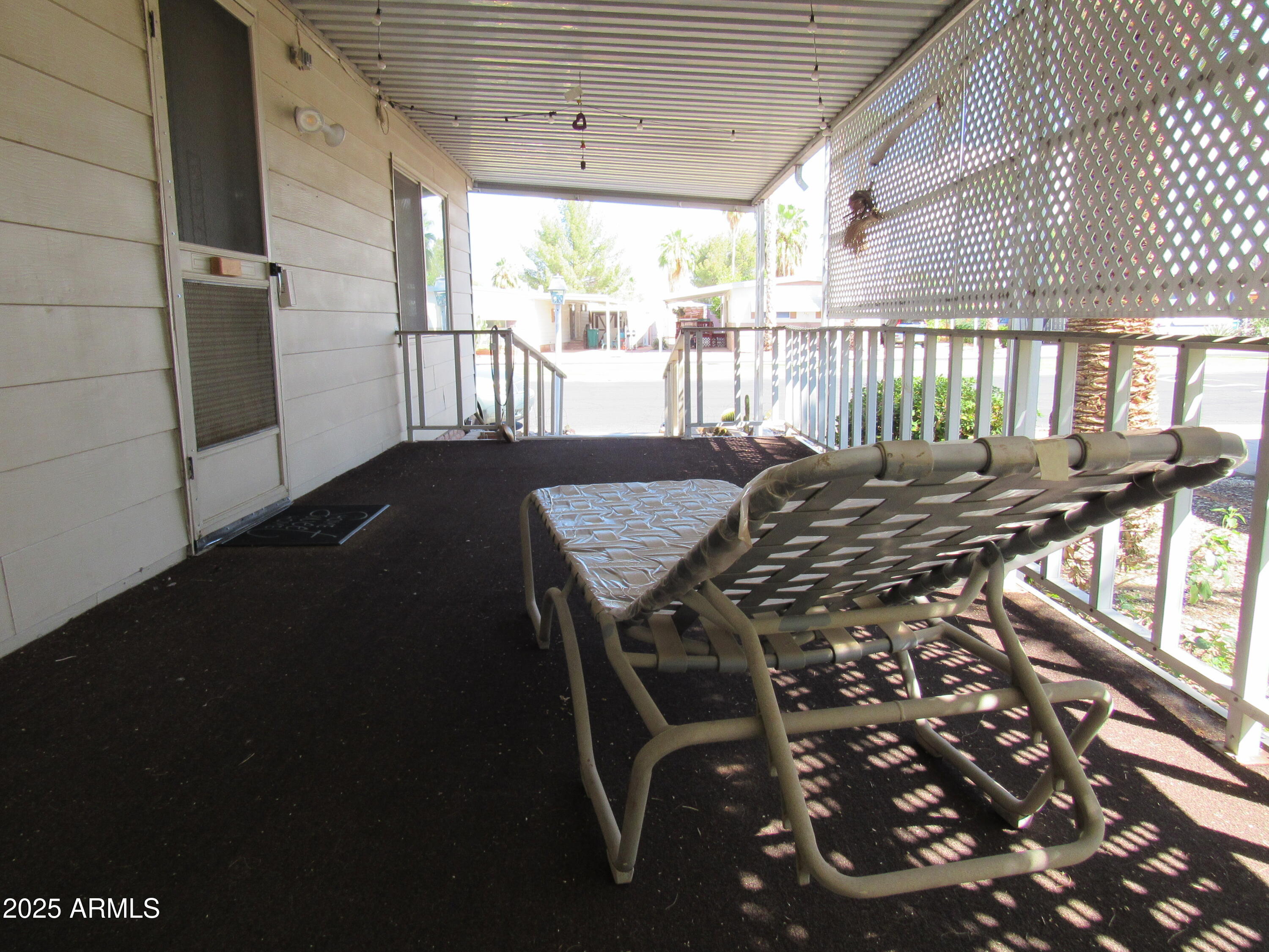3411 South Camino Seco, Unit 213 Tucson, AZ 85730 - Photo 4 of 22 a view of a patio with table and chairs with wooden floor and fence