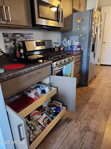 a kitchen with stainless steel appliances granite countertop a stove and a microwave