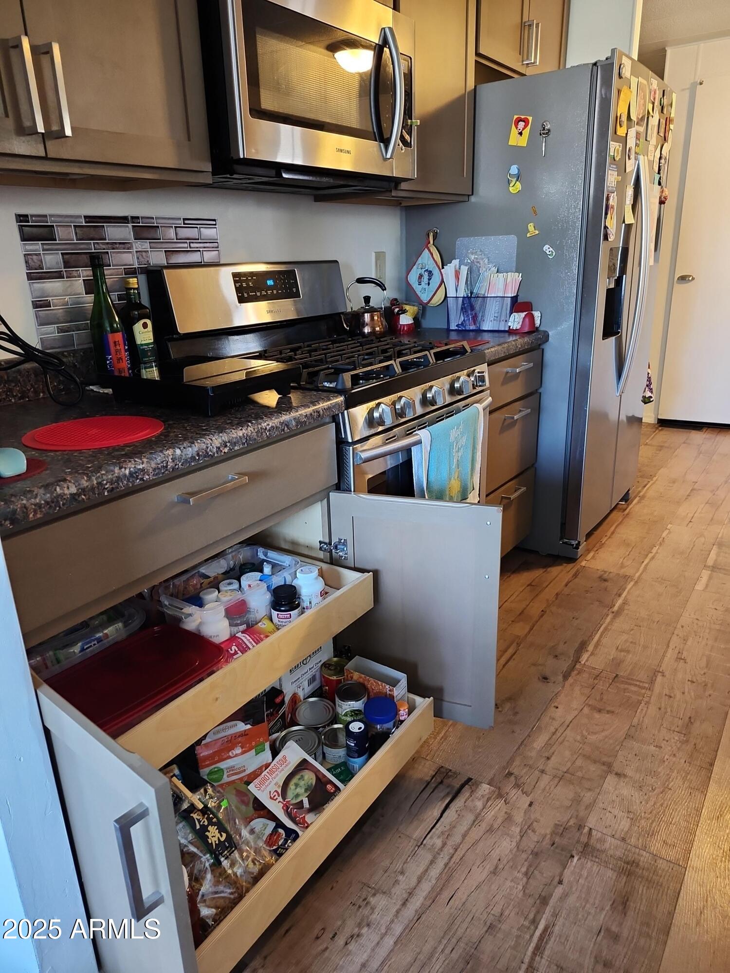 3411 South Camino Seco, Unit 213 Tucson, AZ 85730 - Photo 5 of 22 a kitchen with stainless steel appliances granite countertop a stove and a microwave
