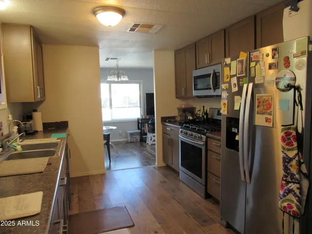 a kitchen with stainless steel appliances a stove a refrigerator and a sink