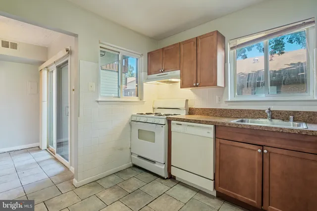 a kitchen with a sink window and cabinets