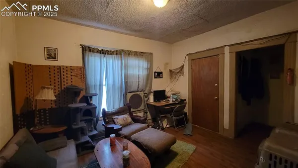 a living room with furniture a desk and chair with wooden floor