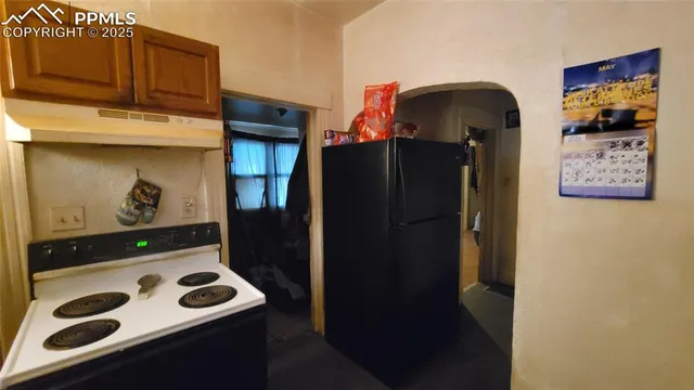 a view of a kitchen with a refrigerator and cabinets