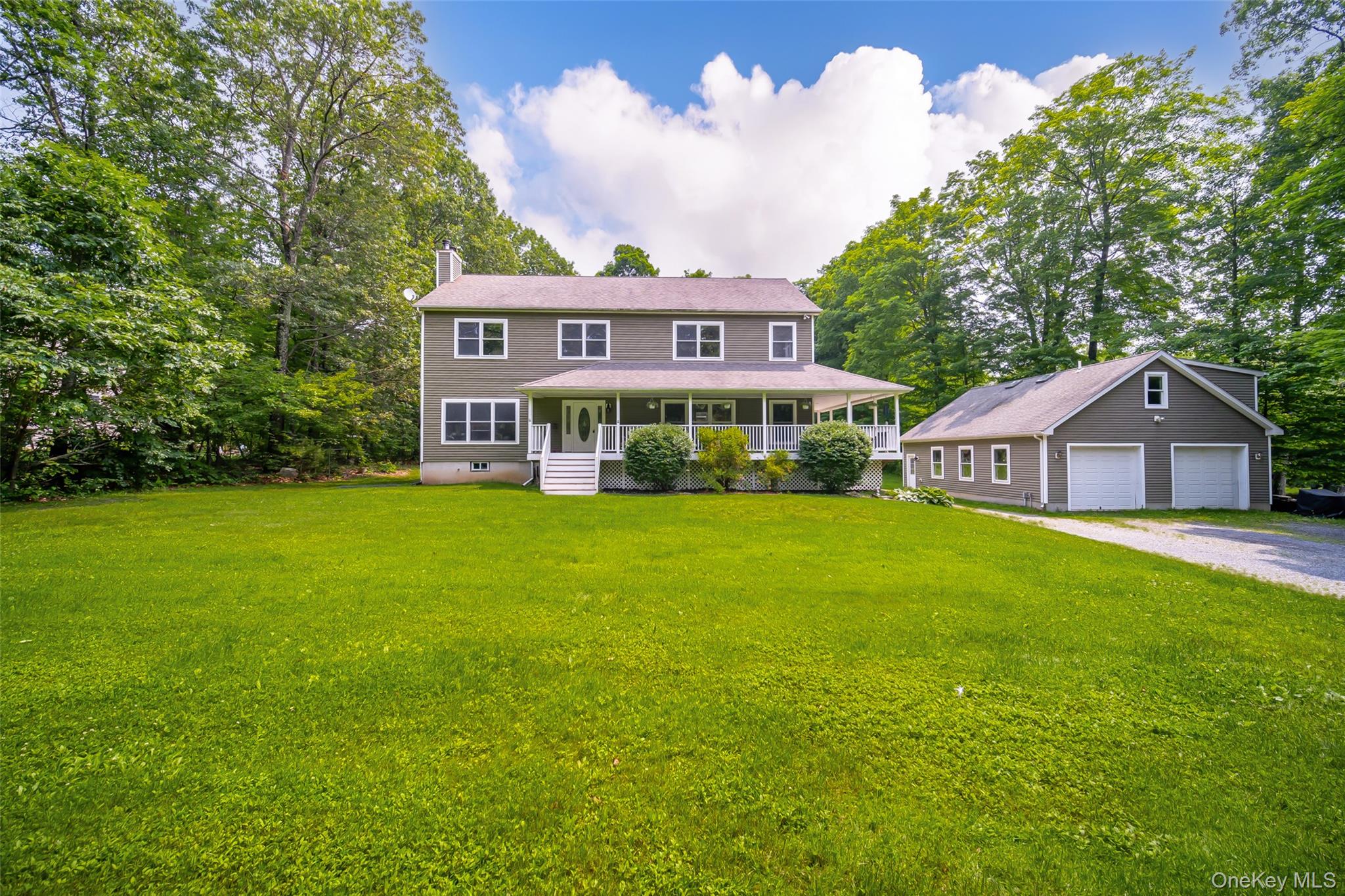 a front view of house with yard and trees in the background