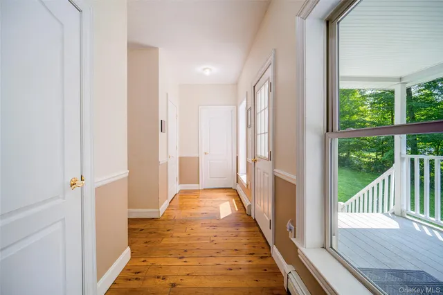 a view of a hallway with wooden floor and a window