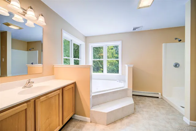 a white bath tub sitting in a bathroom next to a window