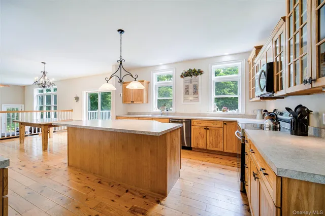 a kitchen with stainless steel appliances granite countertop wooden floors and white cabinets