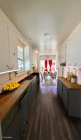 a kitchen with stainless steel appliances wooden floor stove top oven and cabinets