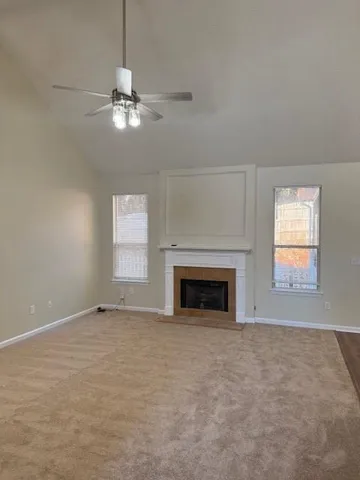 an empty room with windows and fireplace