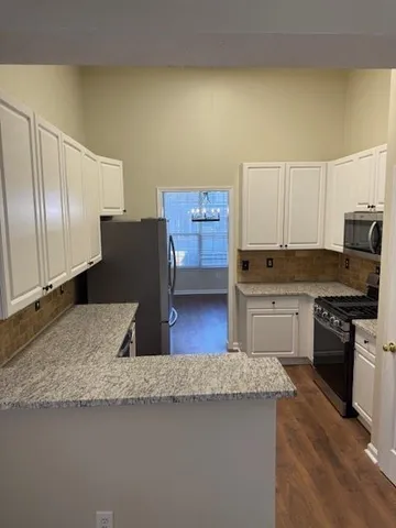 a kitchen with stainless steel appliances granite countertop a stove a sink and a granite counter tops